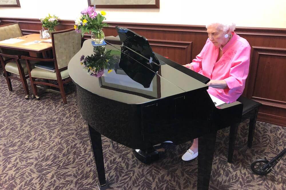 Village at Mercy Creek resident playing piano