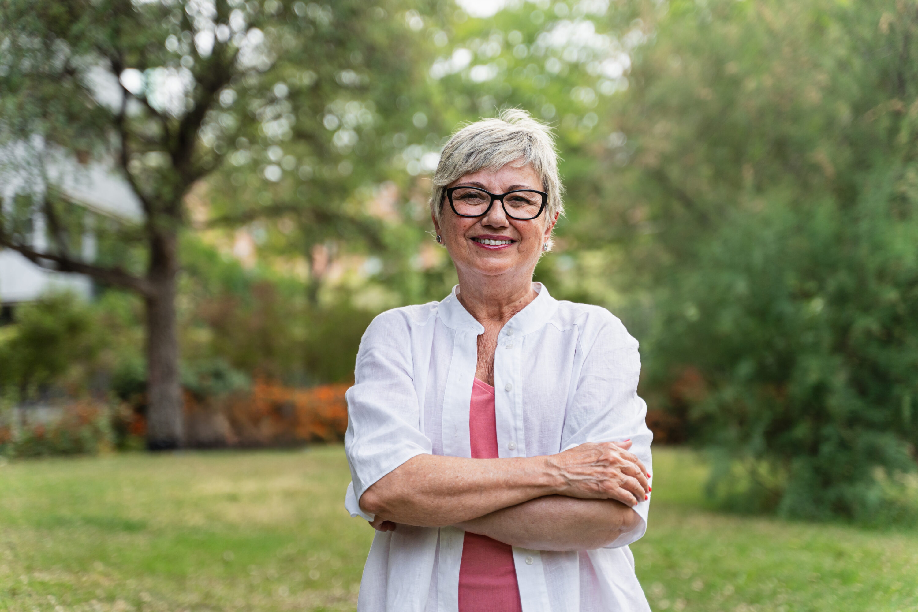 Smiling older woman with glasses in park
