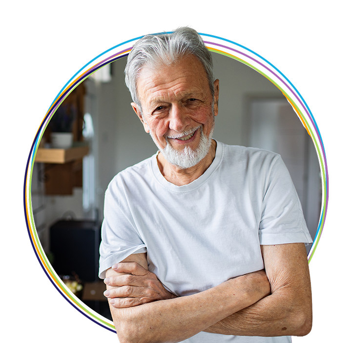 Smiling elderly man with crossed arms indoors