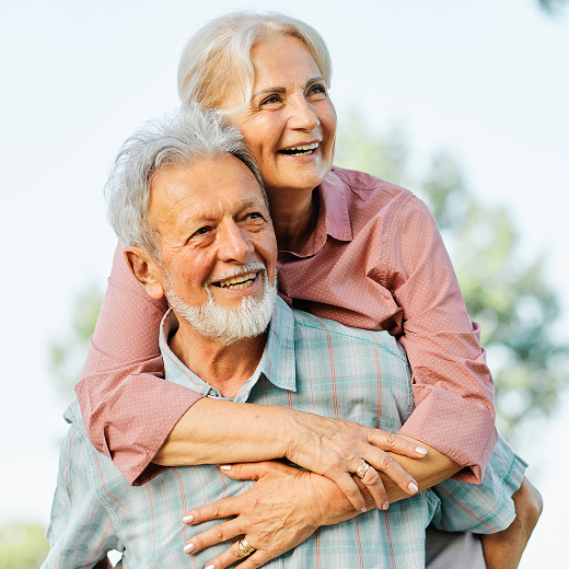 Happy elderly couple embracing outdoors in soft daylight