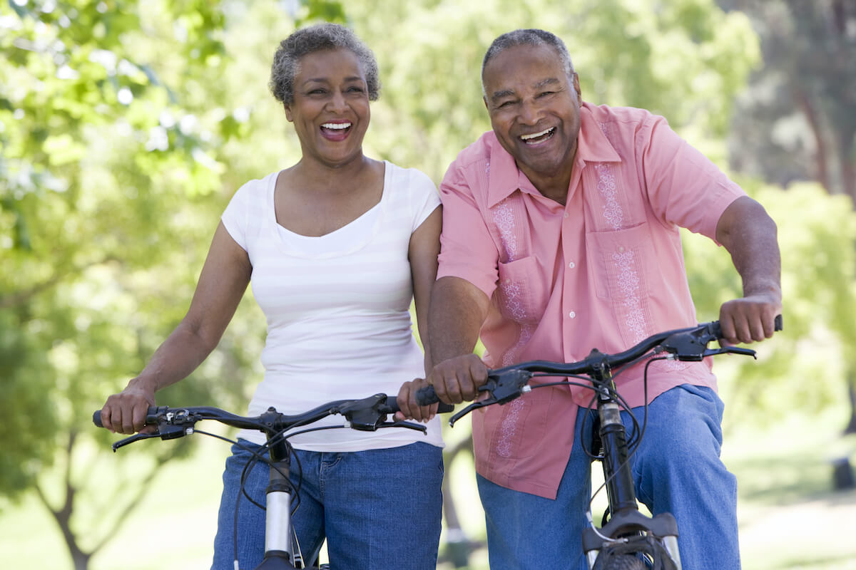 Smiling senior couple riding bicycles in park