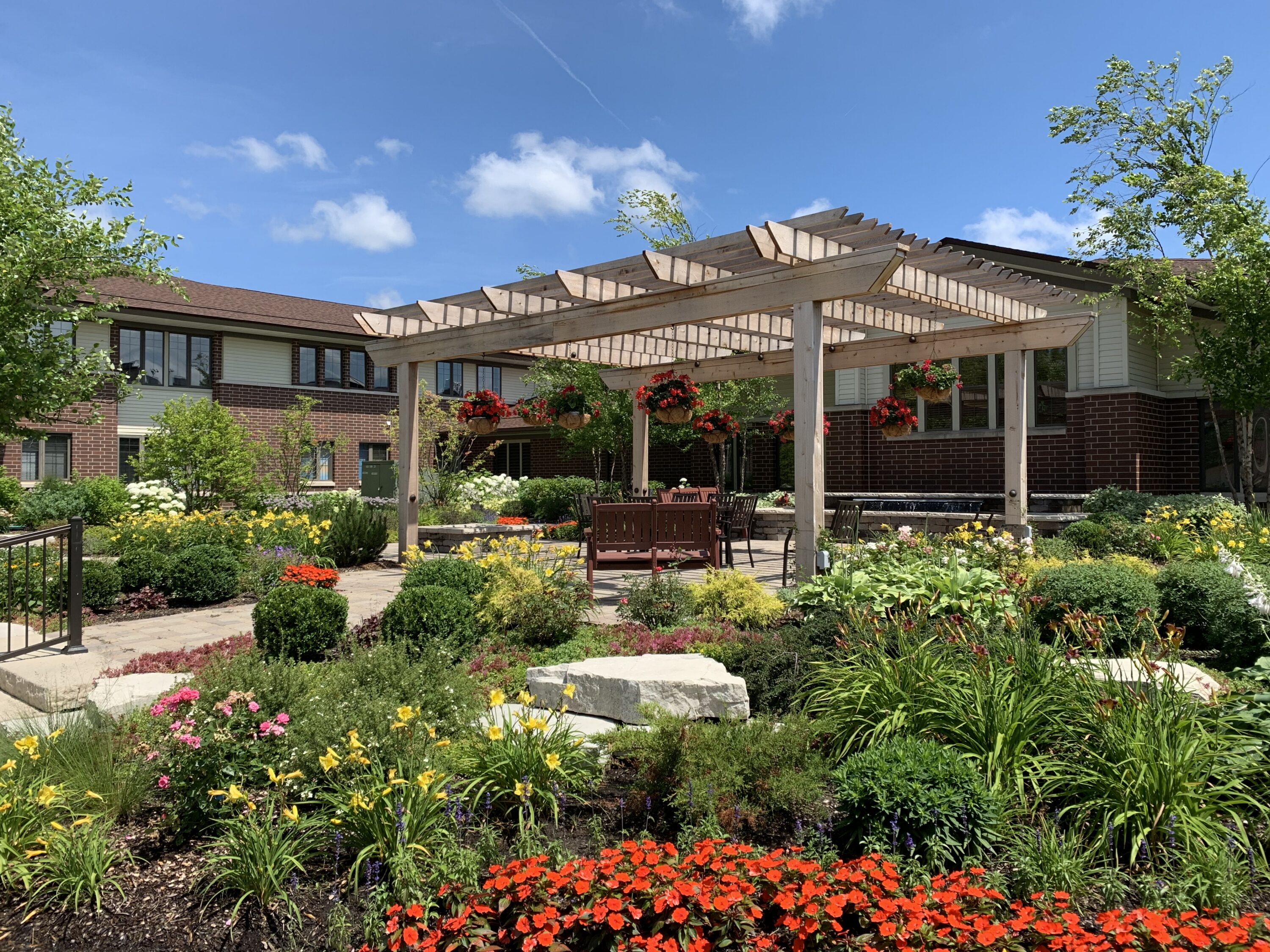 Landscaped courtyard with wooden pergola and colorful flowers