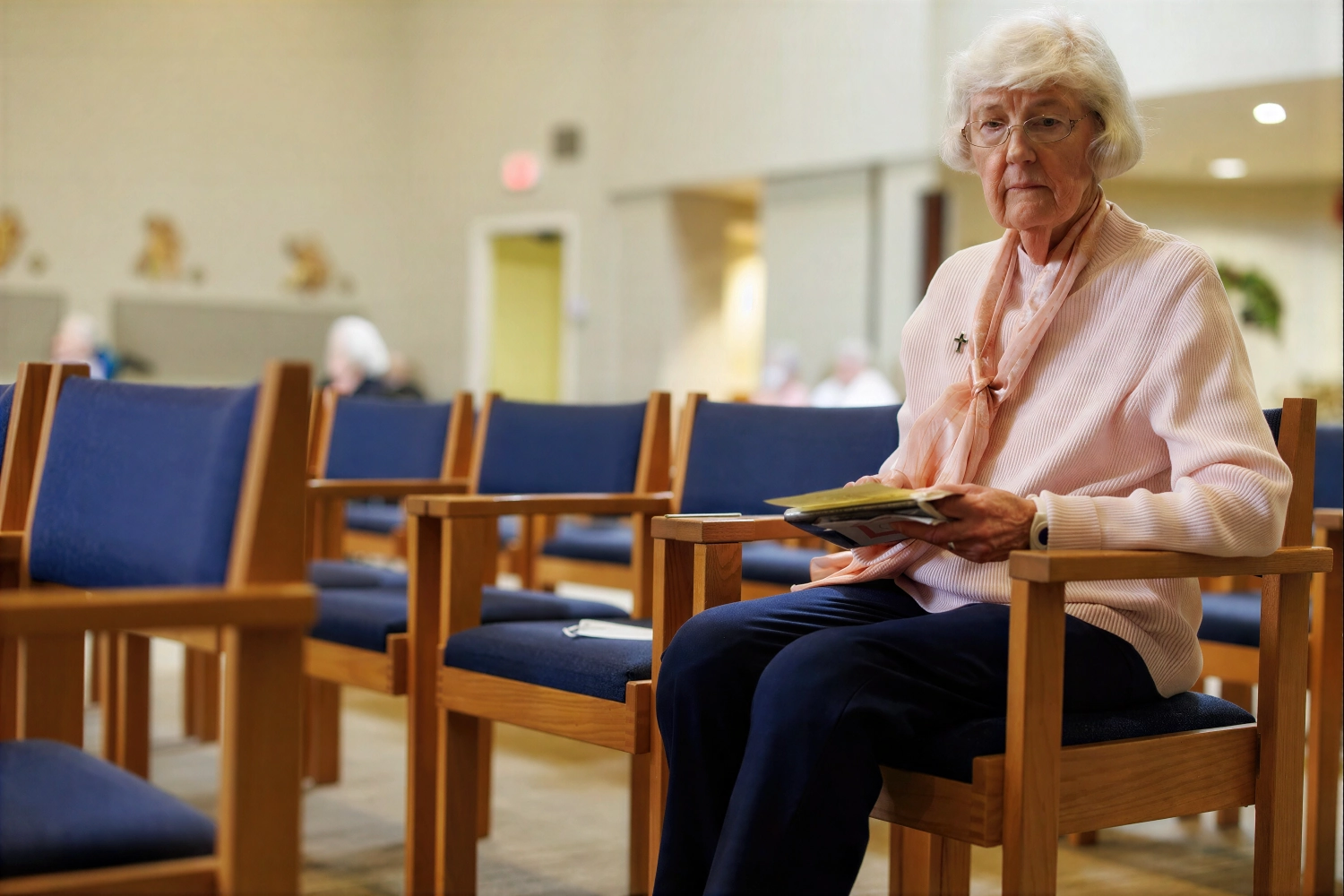 Elderly woman holding program in church seating