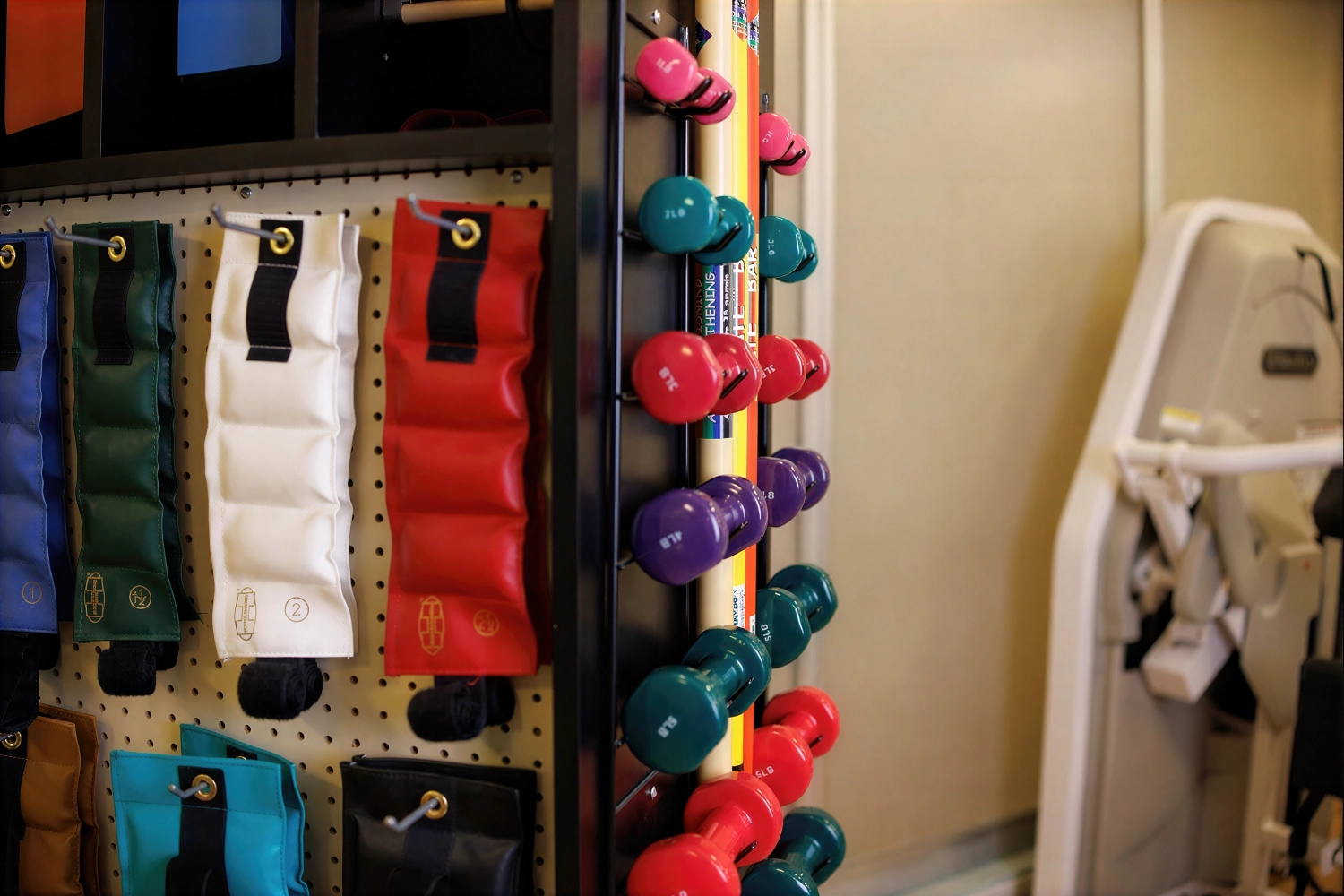 Colorful dumbbells and resistance bands in fitness room