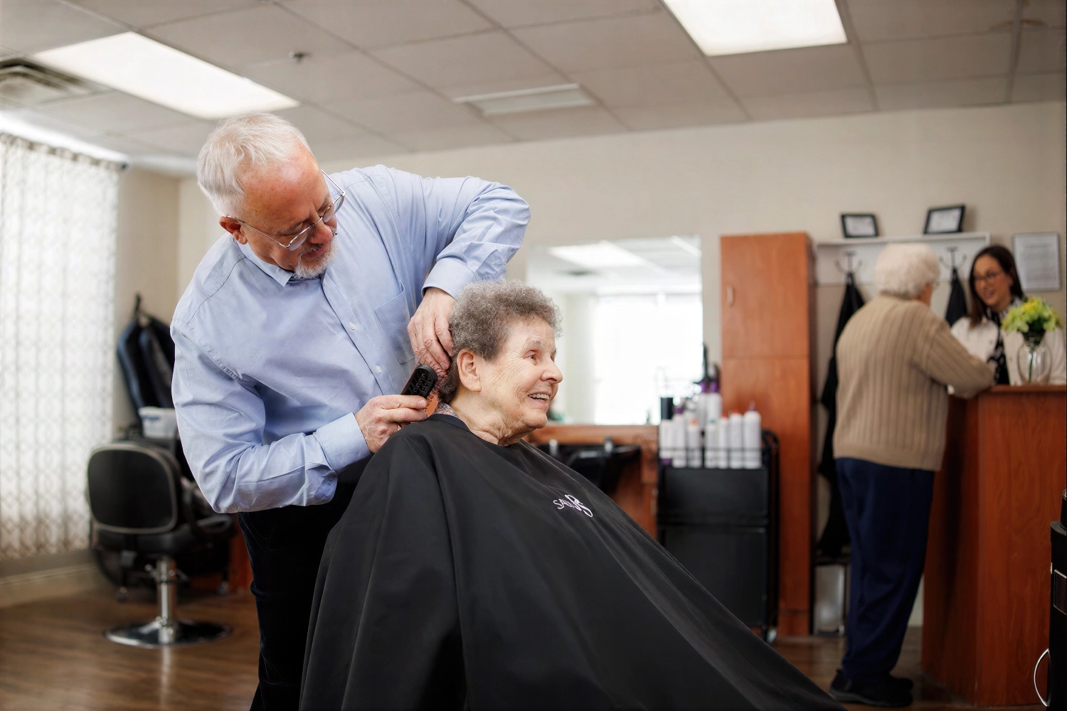 Elderly woman smiling during haircut at salon