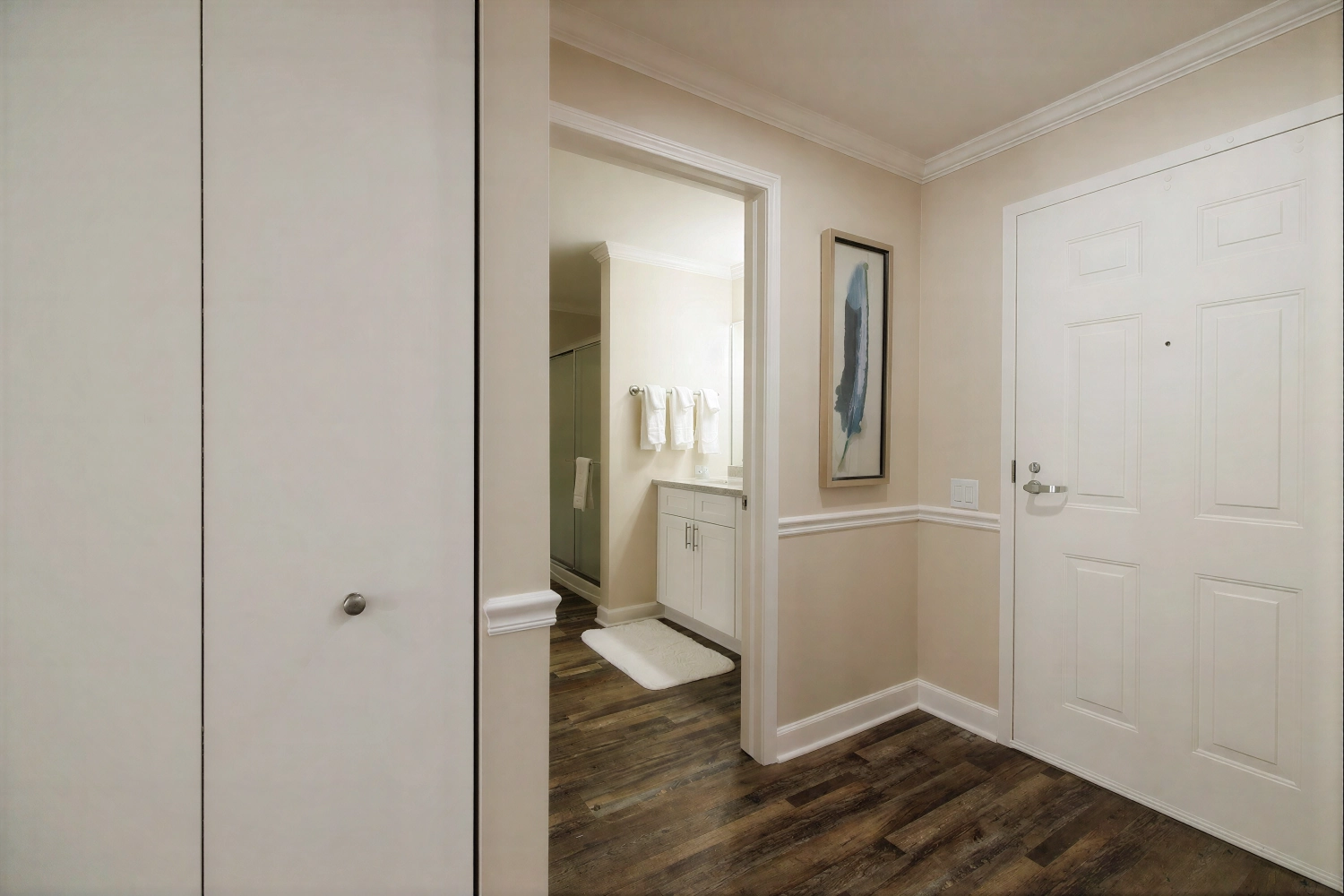 Hallway with wood floors leading to bathroom