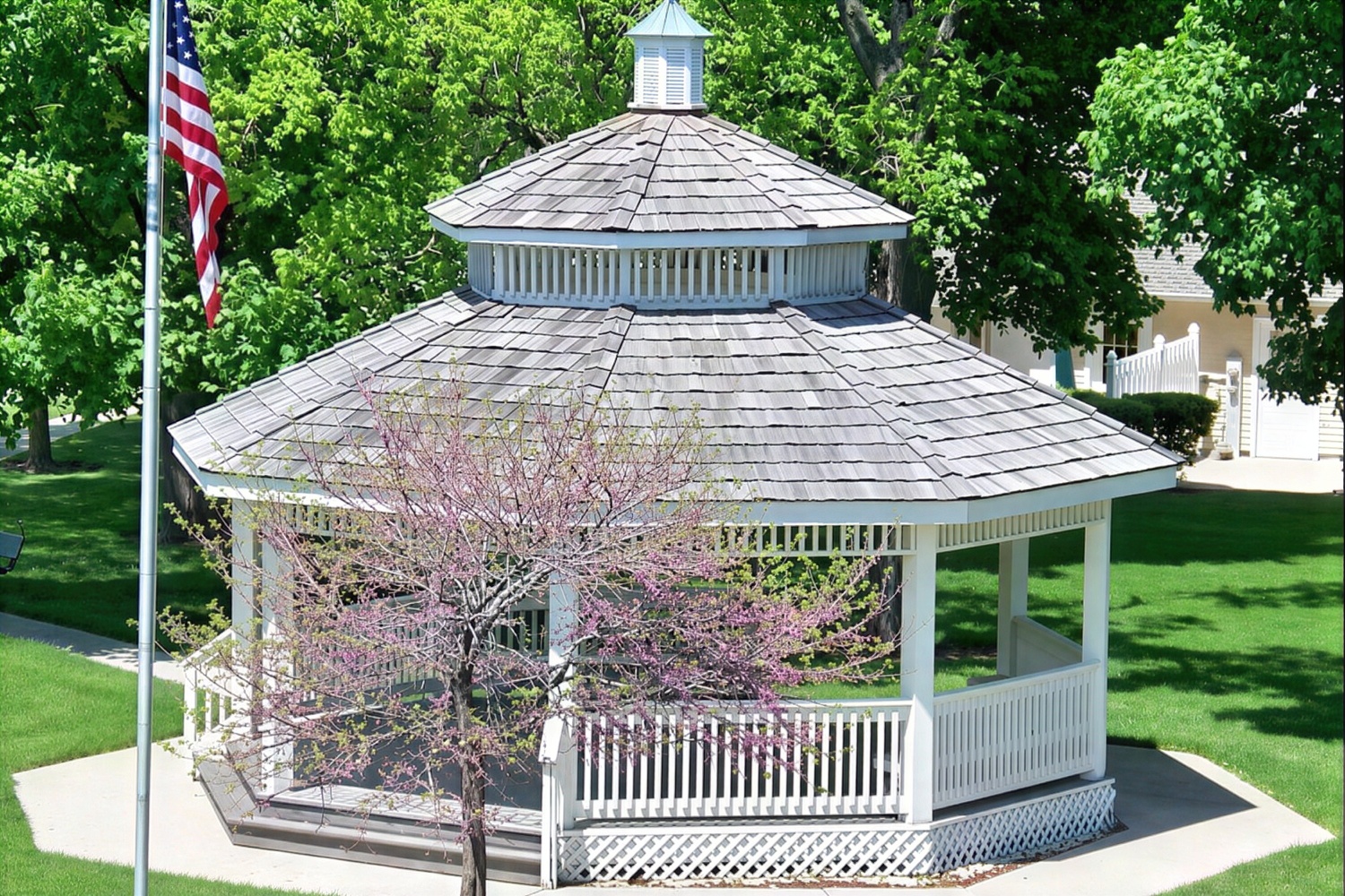 White gazebo in green park with American flag