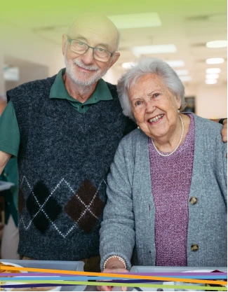 Smiling elderly couple standing together indoors