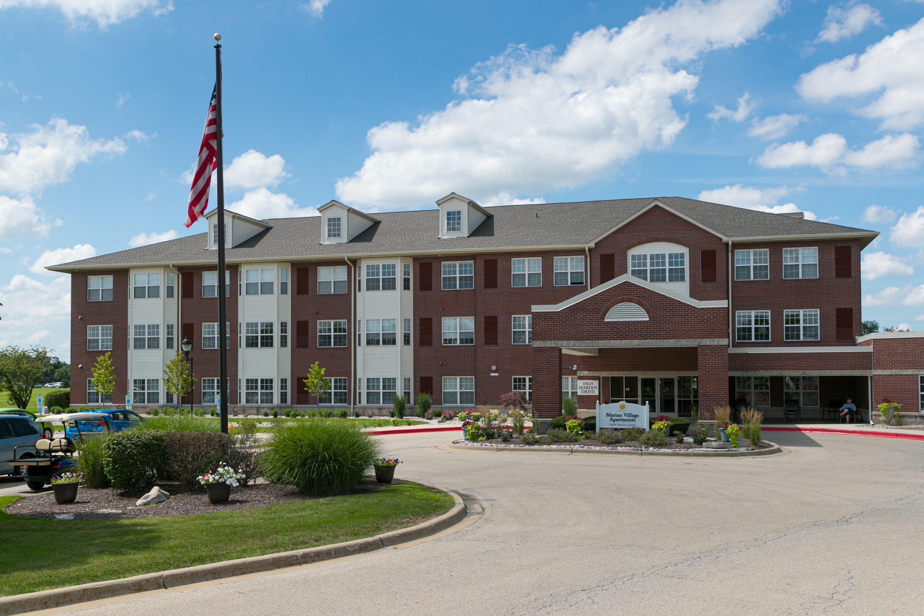 Three-story brick apartment building with American flag