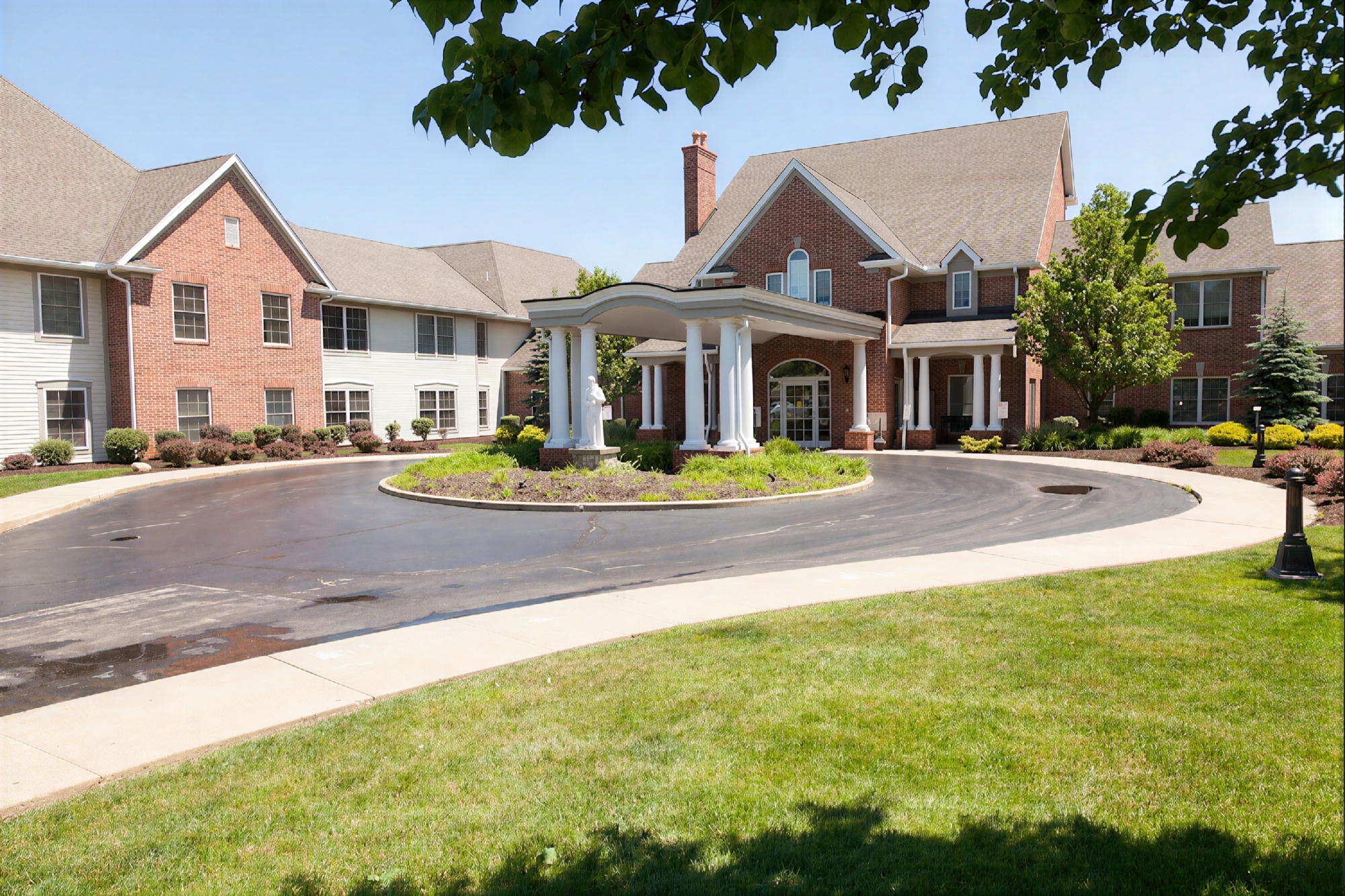 Brick residential building with columned entrance and driveway