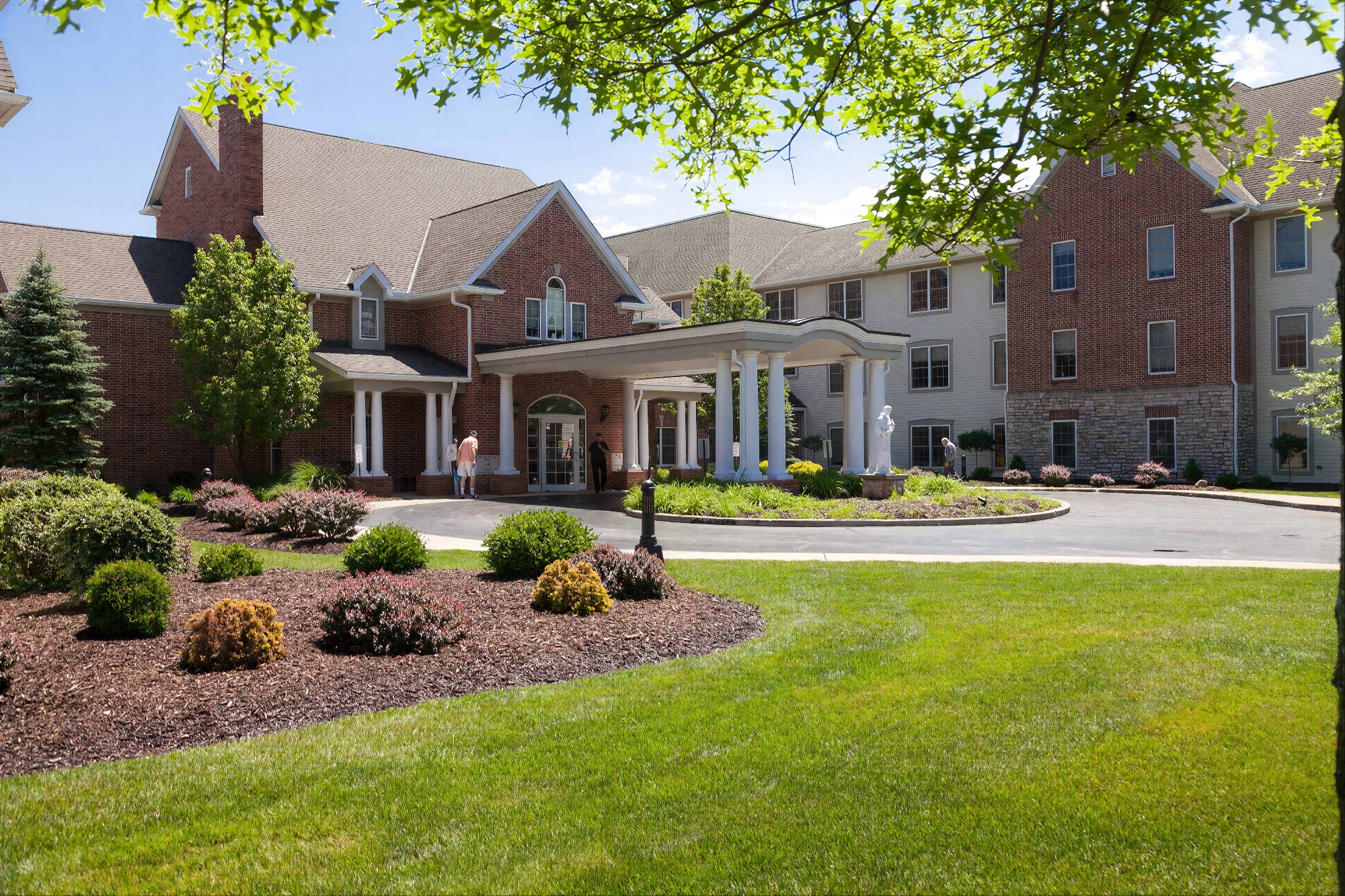 Brick senior living community with landscaped entrance