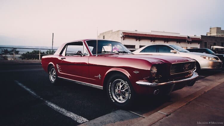 Classic red Ford Mustang parked at sunset