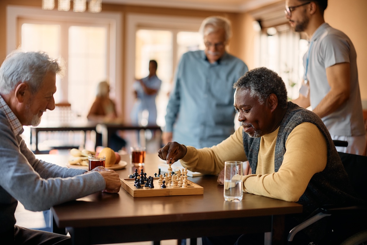 Two elderly men playing chess indoors