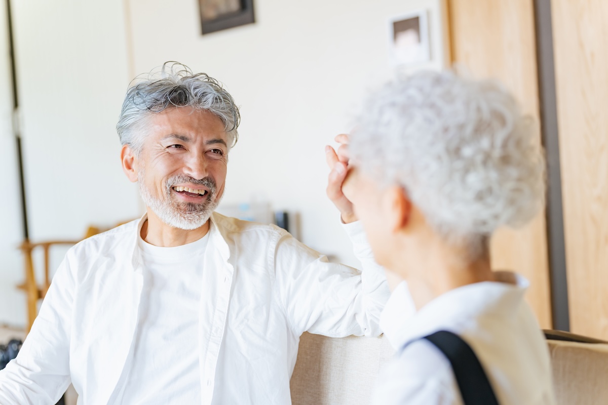 Smiling senior couple talking on living room couch