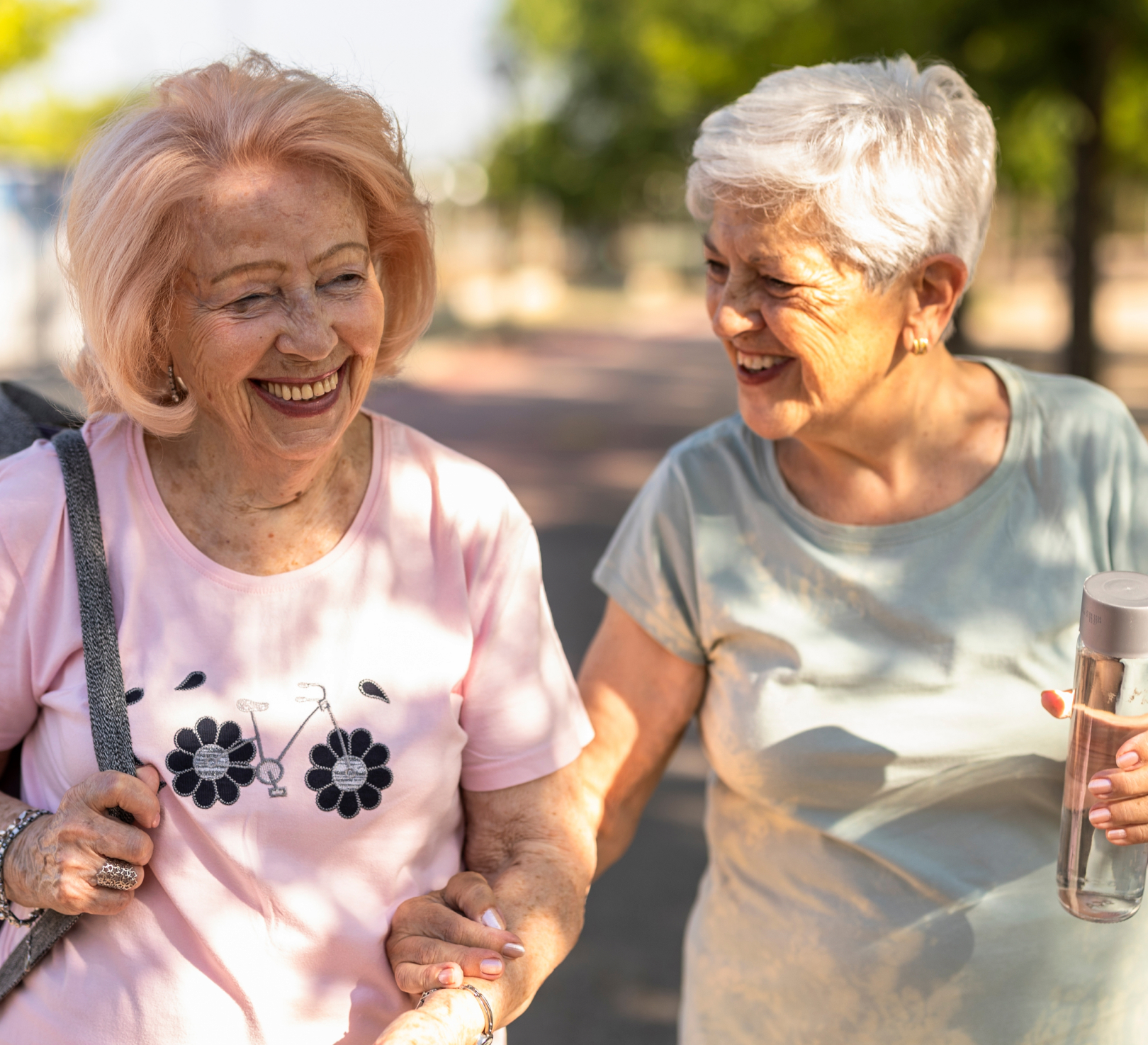 Two elderly women smiling on a sunny walk