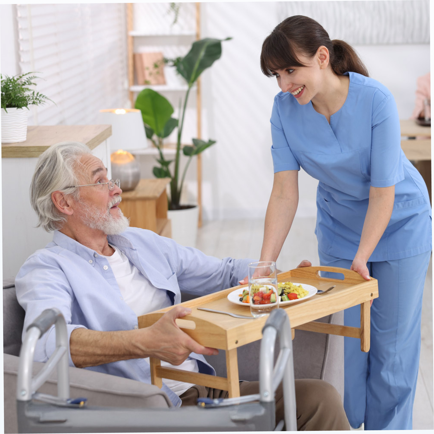 Caregiver serving meal to elderly man at home