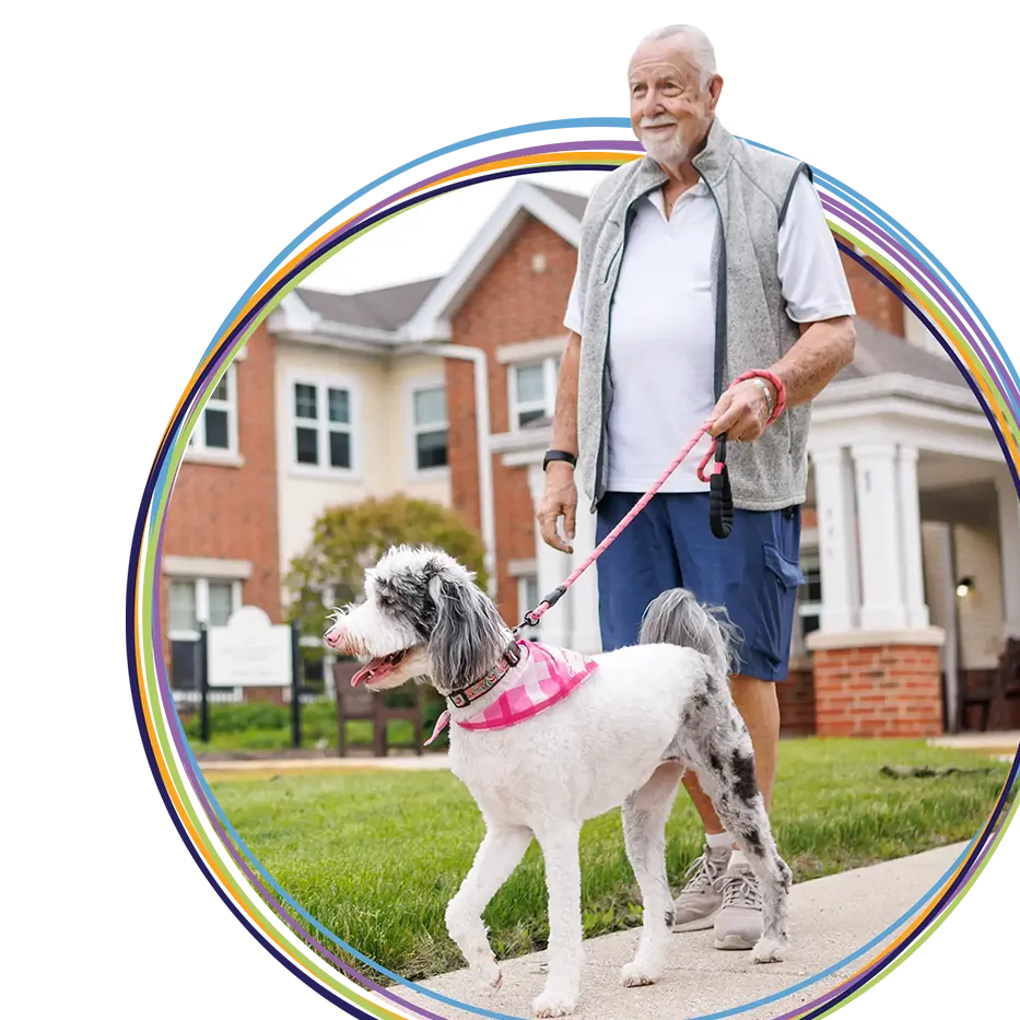 Elderly man walking small dog outdoors