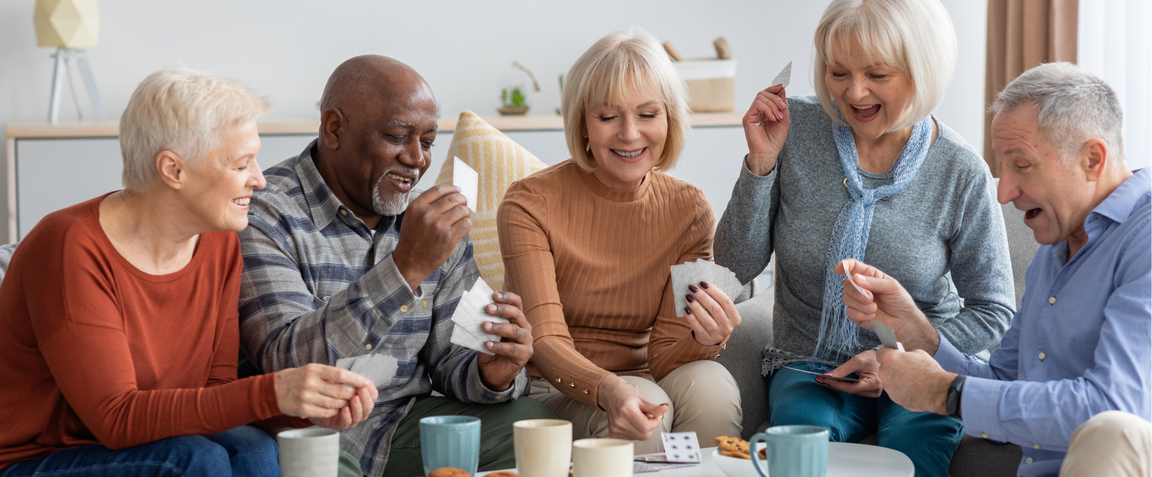 Group of seniors playing cards together indoors