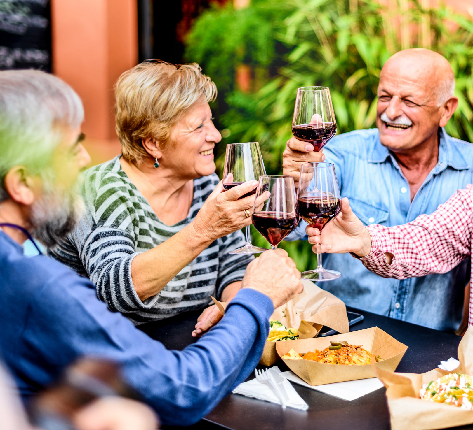 Friends toasting red wine at outdoor restaurant