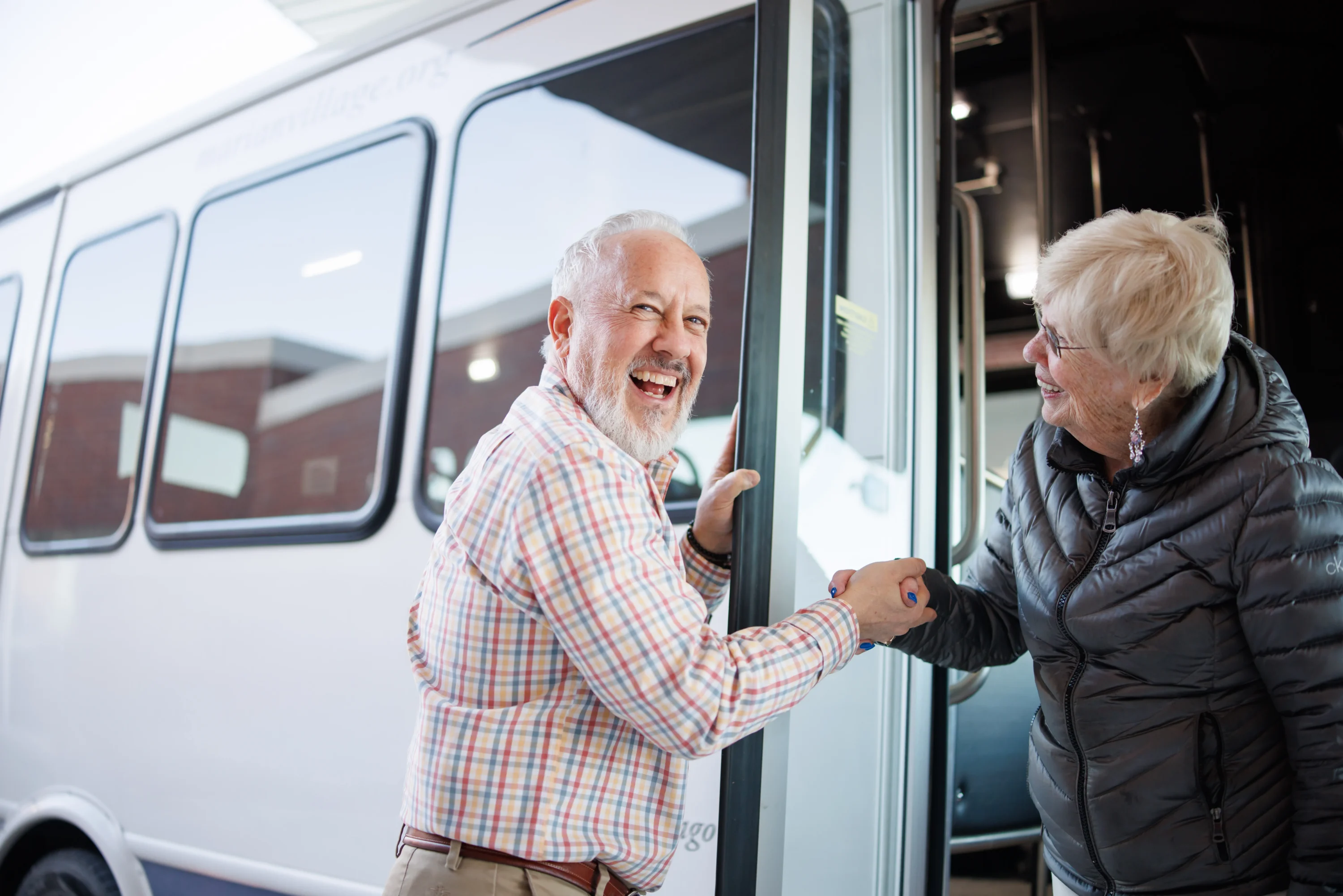 Smiling senior couple boarding recreational vehicle together