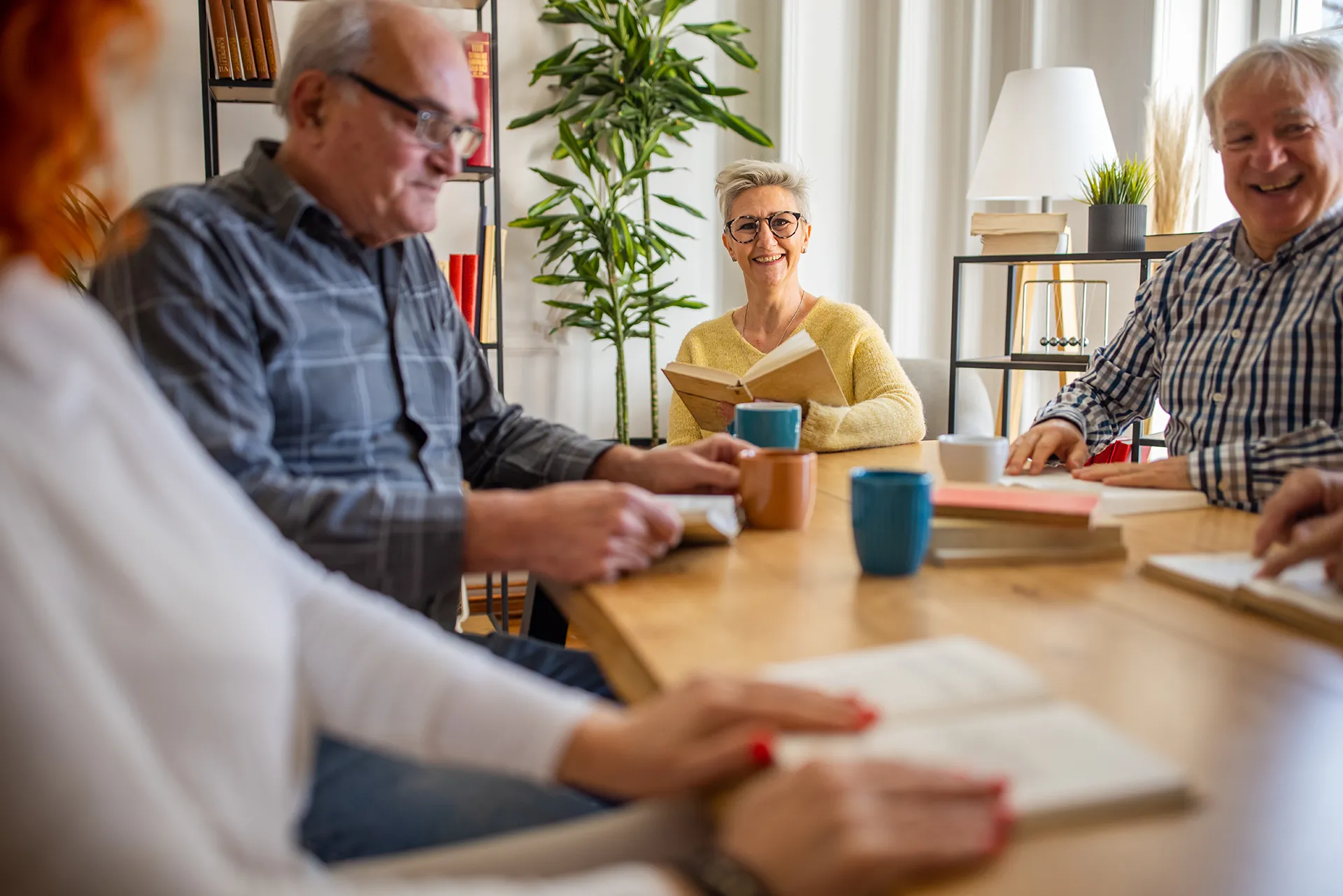 Seniors reading books together at a table