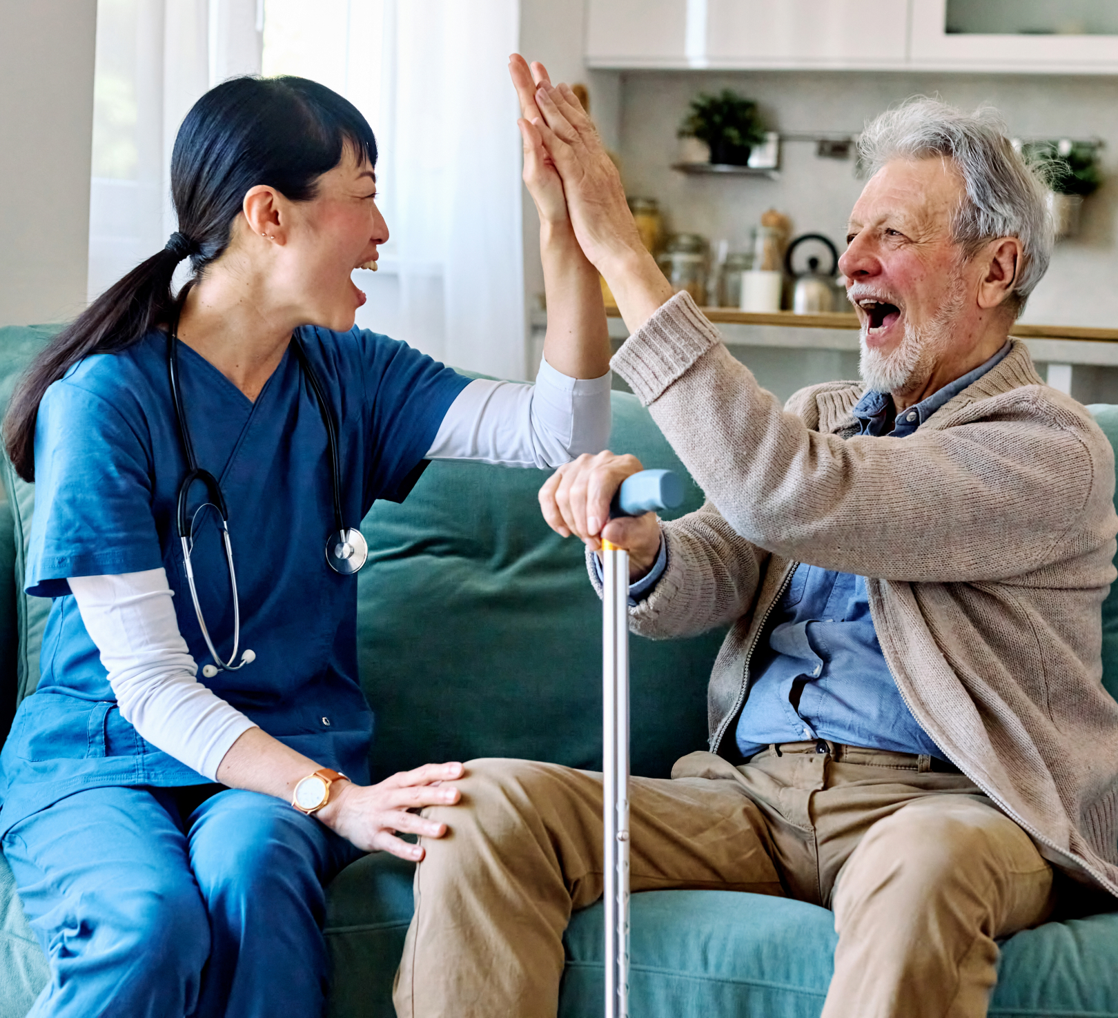 Caregiver and senior man high-fiving on couch