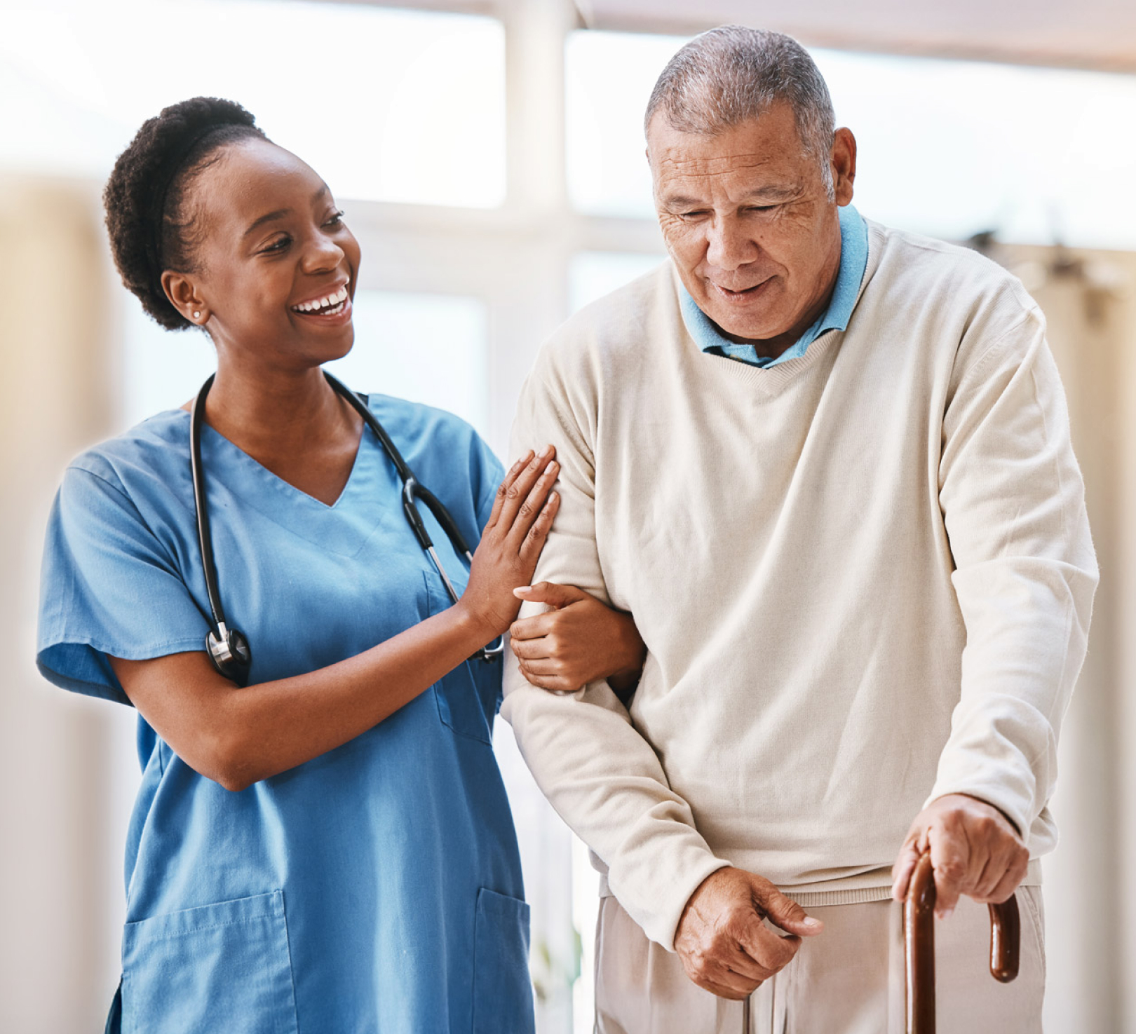 Nurse assisting elderly man with cane indoors