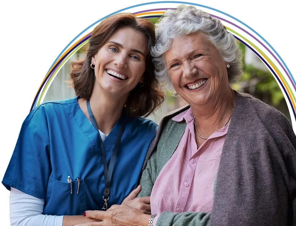 Smiling caregiver and elderly woman embracing