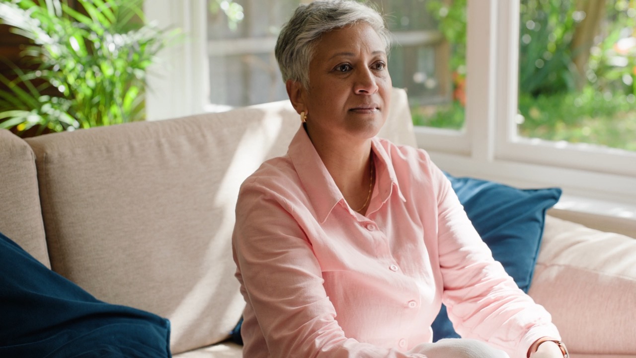 Woman with short gray hair sitting on couch