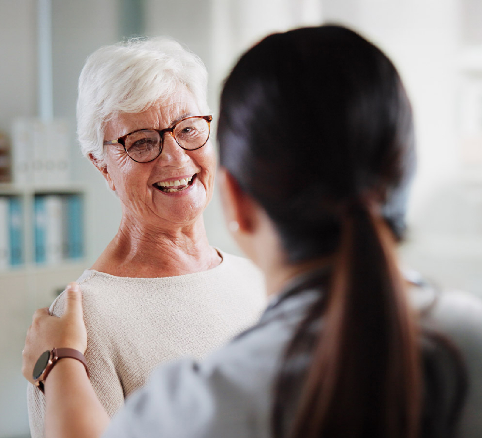 Smiling senior woman with caregiver at home