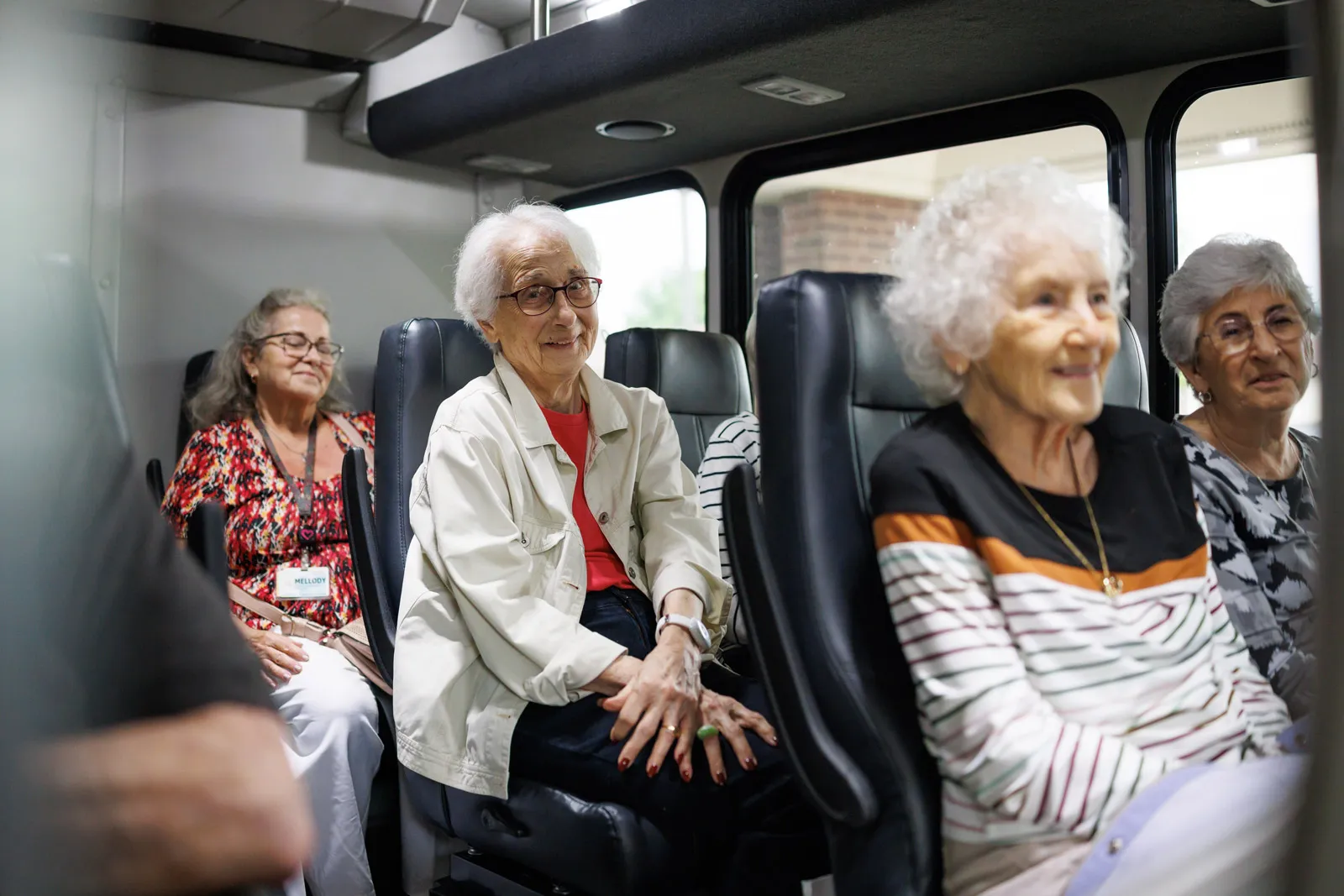 Senior women smiling while riding a shuttle bus