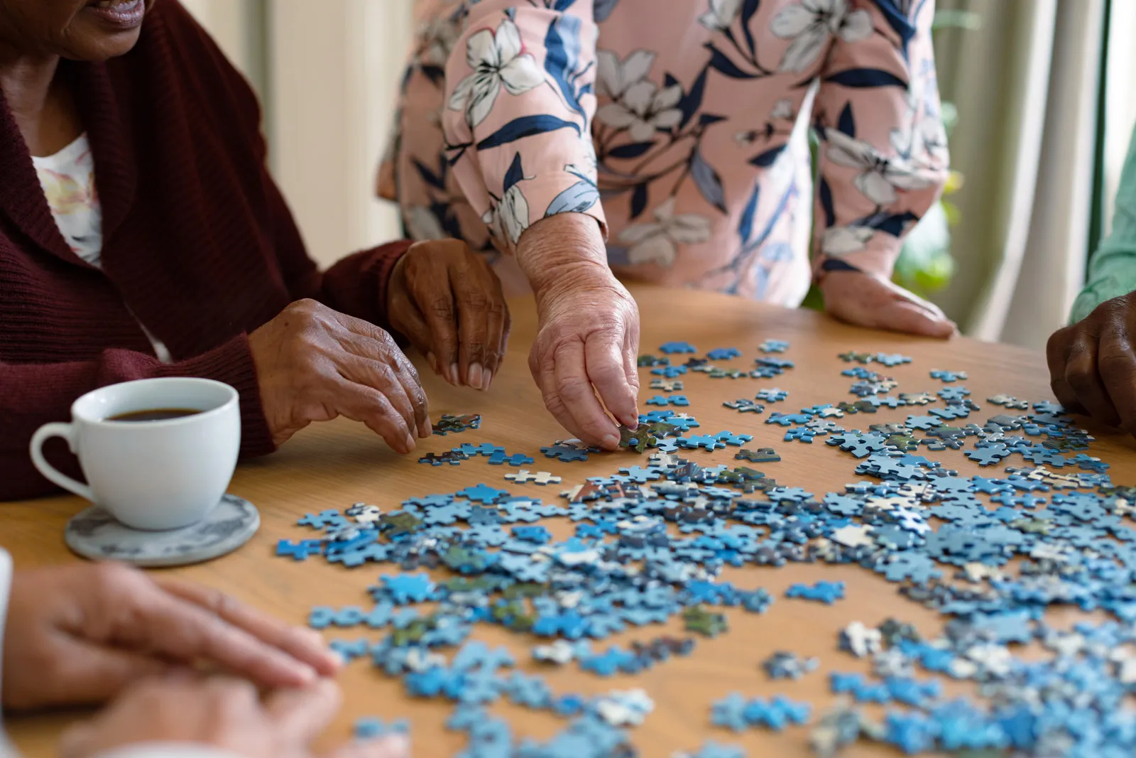 Seniors assembling jigsaw puzzle at table