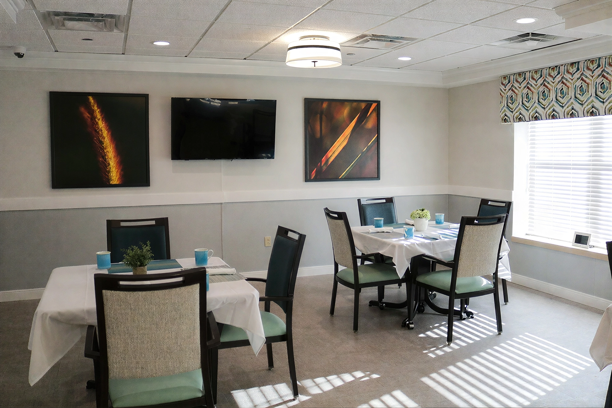 Small dining room with set tables and wall art